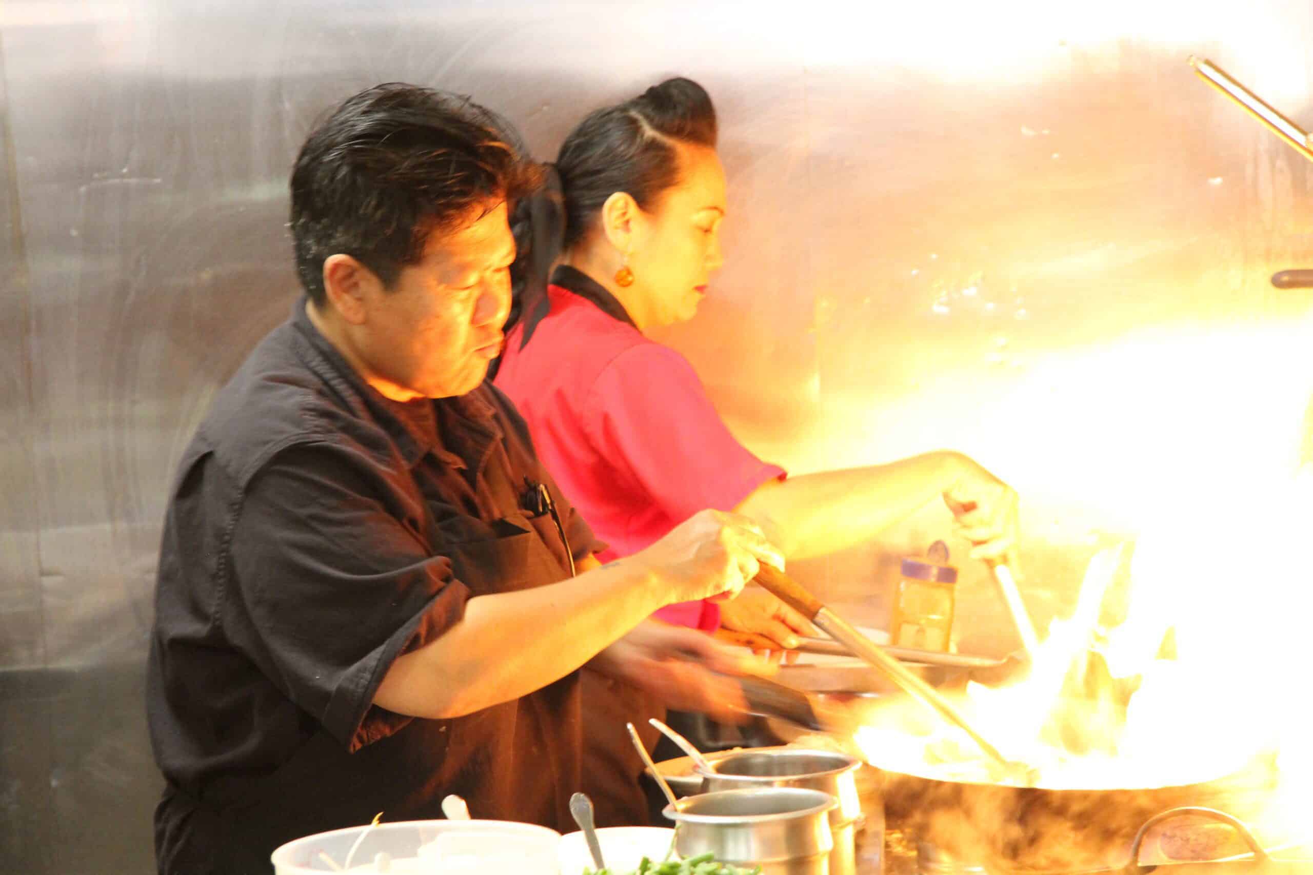 Sasimonthon Ongartsutthikul, a.k.a Andie, owner of Thai Kitchen cooking in the red shirt.